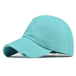 Detail of distressed mint green cotton canvas ponytail baseball cap with torn edges