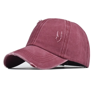 Close-up of vintage burgundy washed cotton baseball cap showing distressed torn details