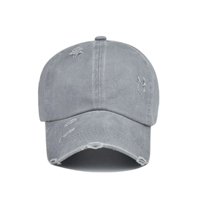 Detail of distressed grey washed cotton baseball cap with vintage frayed hole accents