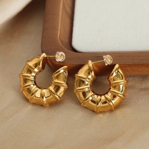 Chic gold plated titanium steel C-shape croissant earrings on silk fabric background