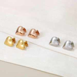 Detailed shot of minimalist heart stud earrings in rose gold, gold and silver finishes