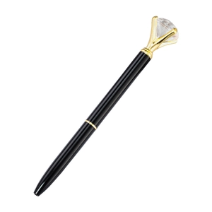 Black metal ballpoint pen with a large crystal diamond top and gold trim on white background