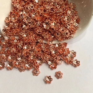 Macro view of rose gold hollow five-petal flower bead spacers for DIY jewelry making