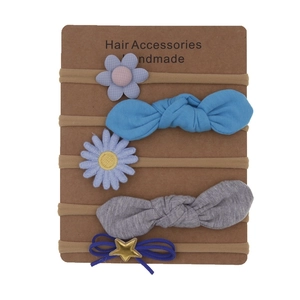 Detail view of 5-piece floral and bow nylon headbands set for baby girls on a display card