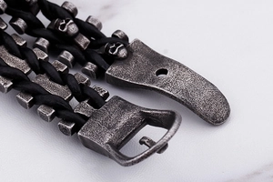Close-up of gothic men's braided leather bracelet with vintage skull charm and buckle