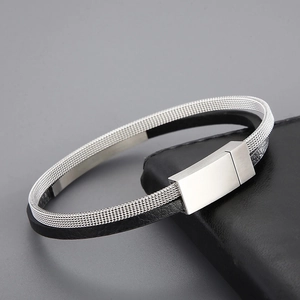 Detail of silver mesh and black leather braided bracelet with magnetic buckle