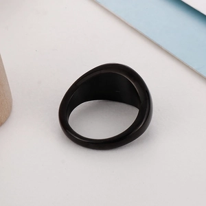Macro close-up of a minimalist wide black resin ring band on a clean white background