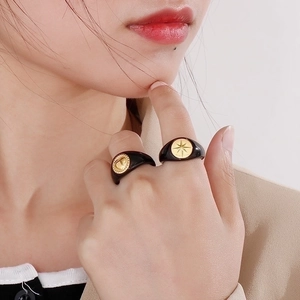 Vintage 18K gold heart and compass star signet rings on model's hand in retro style