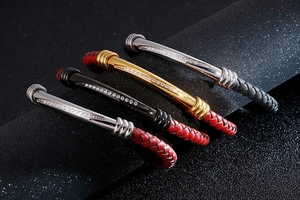 Close-up of woven leather bracelets with curved stainless steel diamond-set tubes