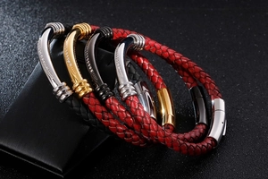 Close-up of woven leather bracelets with curved metal tubes and magnetic clasps