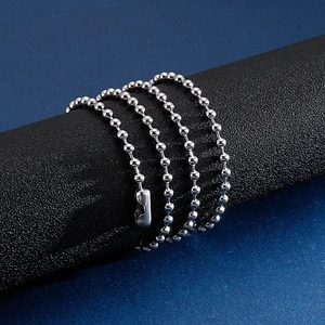Detail of silver stainless steel hollow bead chain necklace wrapped on a black cylinder