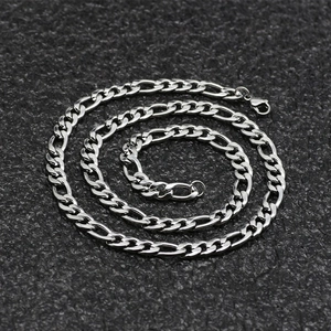 Classic silver Figaro chain necklace for men and women on dark textured background