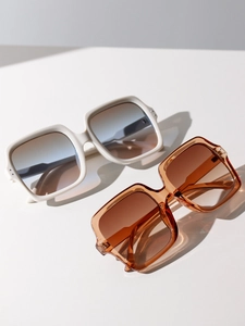 Detail of square oversized sunglasses with gradient lenses and metal rivet accents
