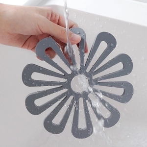 Thick Nordic flower-shaped silicone placemat in grey showing its easy-to-clean design