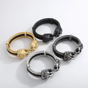 Detail of four wire cable bracelets featuring lion head motifs in various metal finishes