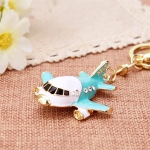 Diamond-encrusted airplane keychain in blue and white metal with sparkling rhinestones