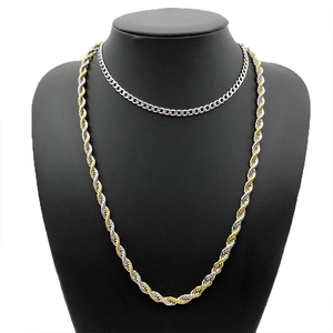 Close-up of silver Cuban chain and two-tone gold twist rope necklace on a black bust