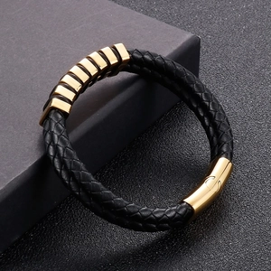 Detail of black braided leather bracelet with golden magnetic clasp on gift box