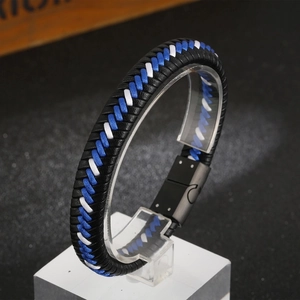 Detail of woven leather bracelet in black, blue and white with black magnetic clasp