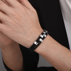 Men's double-layered black braided leather bracelet with stainless steel accents on wrist