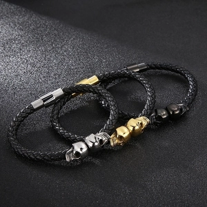 Men's braided leather bracelets with skull charms in silver, gold, and black metal finishes