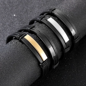 Detail view of double-layer braided leather bracelets with polished metal ID plates