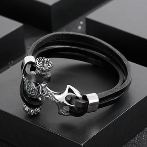 Detail view of leather wrap bracelet featuring a silver anchor clasp and mini compass