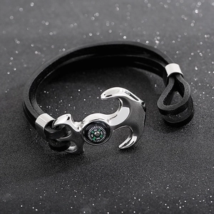 Macro detail of men's leather anchor bracelet featuring a built-in functional compass dial