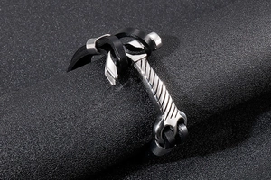 Close-up of braided leather cord with silver stainless steel hammer charm on dark background