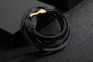 Close-up of black braided leather multi-layer bracelet with golden fishhook clasp