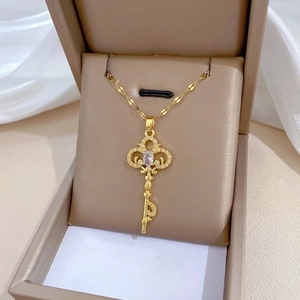Elegant gold titanium necklace featuring a luxury key pendant with sparkling crystal inlay