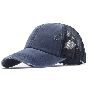 Dettaglio cappellino in denim lavato con retro a rete e ricamo vintage sulla parte frontale