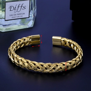 Detail of gold woven stainless steel bangle with mesh texture and rectangular end caps