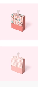 Detailed view of mini pink gift boxes with ribbon handles and summer beach patterns