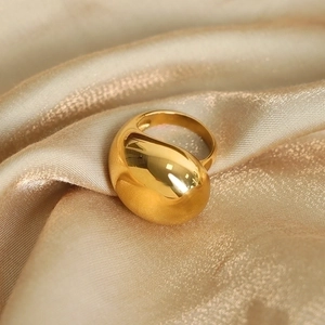 Polished gold-plated geometric irregular water drop ring on champagne silk background