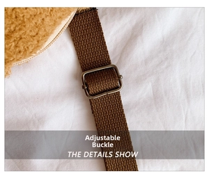 Detail view of the adjustable metal buckle and durable brown woven strap on plush bear bag