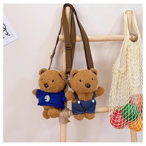 Detail of plush bear crossbody bags in blue daisy hoodie and denim overalls