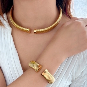 Detail of 18K gold plated spiral choker and matching cuff bracelet set on a female model