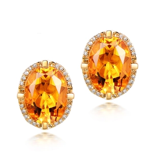 Macro view of oval yellow gemstone earrings with halo diamonds and golden finish