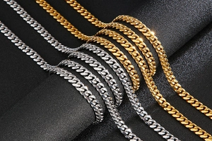 Close-up of 8mm gold and silver polished stainless steel Cuban chains on black background