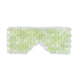 Handmade light green Xiuyan jade eye mask with beaded weaving design on white background
