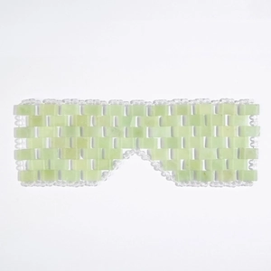 Detail of hand-woven light green jade eye mask with transparent beads and cooling texture