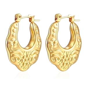 Detailed macro view of gold-plated hollow hoop earrings with vintage relief pattern