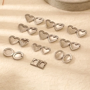 Polished stainless steel locket pendants in heart and oval shapes on beige paper