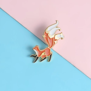 Exquisite nine-tailed fox enamel pin in orange and white with a gold metal finish
