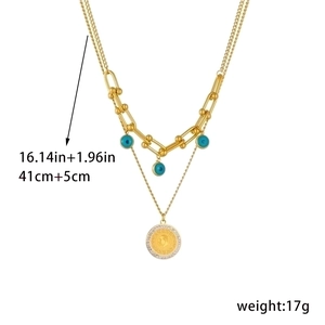 Detail of double-layer gold chain necklace with coin pendant and blue beads