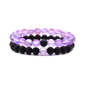Detail view of 8mm natural lava rock and tiger eye beaded stretch bracelets on white background