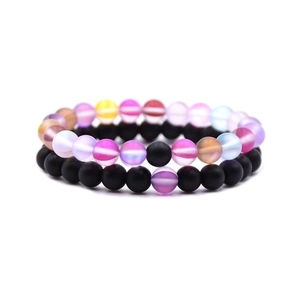 Detailed close-up of matte black and iridescent beaded stretch bracelets set