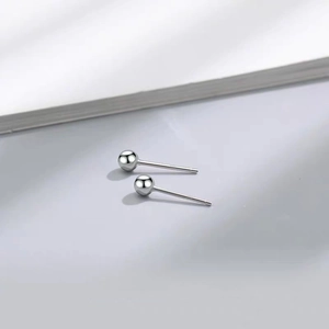 Macro shot of minimalist S925 sterling silver ball stud earrings with polished finish