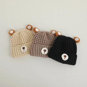 Winter knitted baby hats with bear ears in beige, brown and black colors